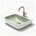 Ceramic bathroom sink in green and white finish with brushed nickel faucet